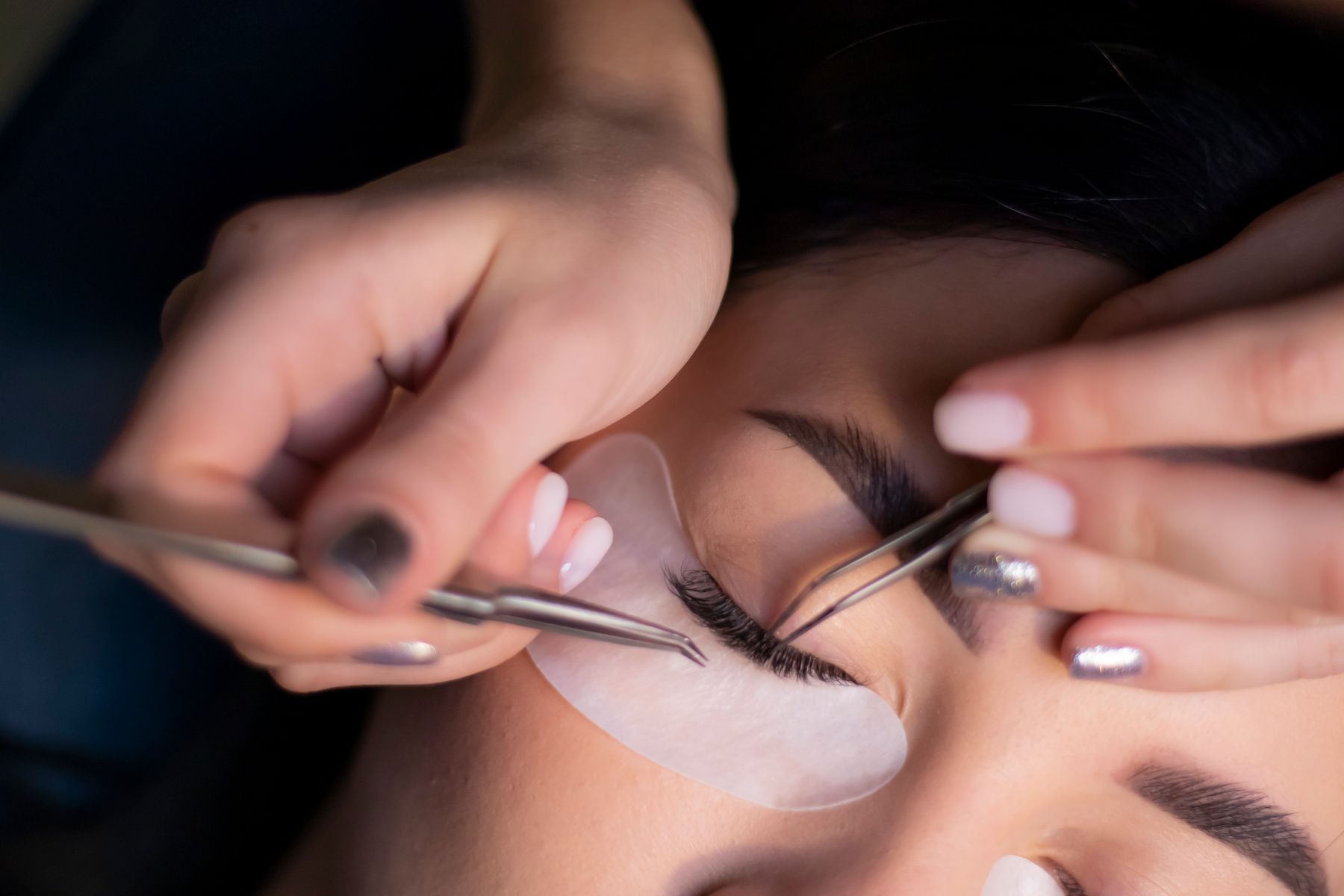 Beautician working with fine tweezers